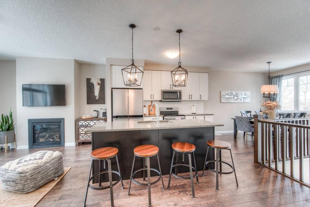a kitchen with a island with bar stools at Riverside Villa in Kitchener