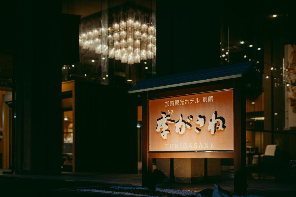 una señal frente a una tienda con una lámpara de araña en Tokigasane, en Kaga