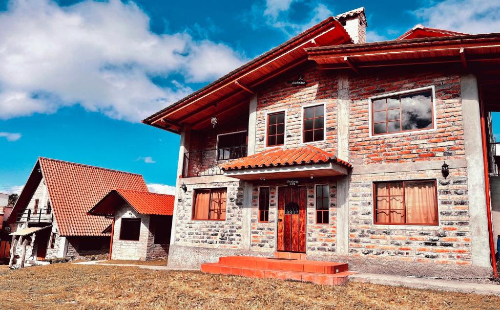 uma antiga casa de tijolos com um telhado vermelho em Mateospaxi em Machachi