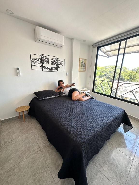 une femme dormant sur un lit dans une chambre dans l'établissement Hermoso ApartaEstudio Centrico, à Cartago