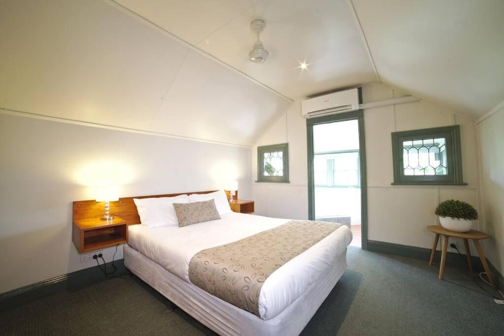 - une chambre avec un grand lit blanc et une fenêtre dans l'établissement 2 Bedroom Self Contained Apartment with Spa, à Ballarat