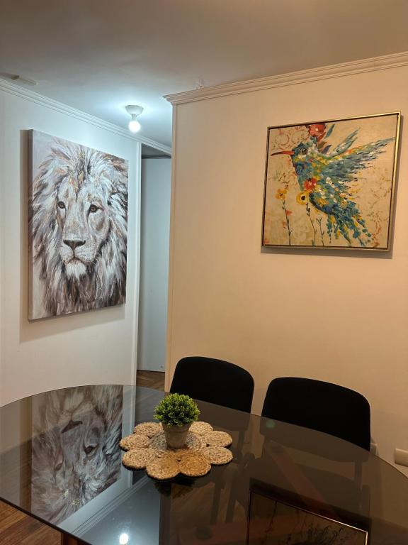 a dining room with a glass table and a painting at Apartamento punta Arenas in Punta Arenas
