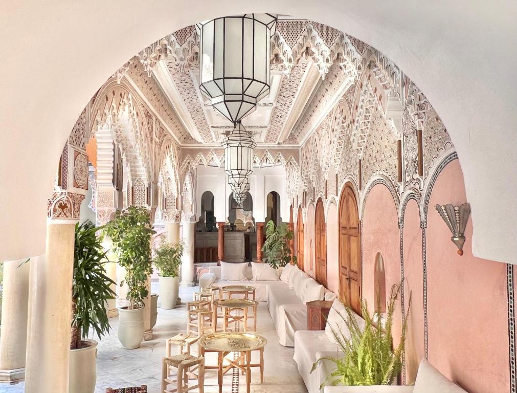 una stanza decorata con tavoli e sedie in un edificio di Riad Azad & Spa a Marrakech
