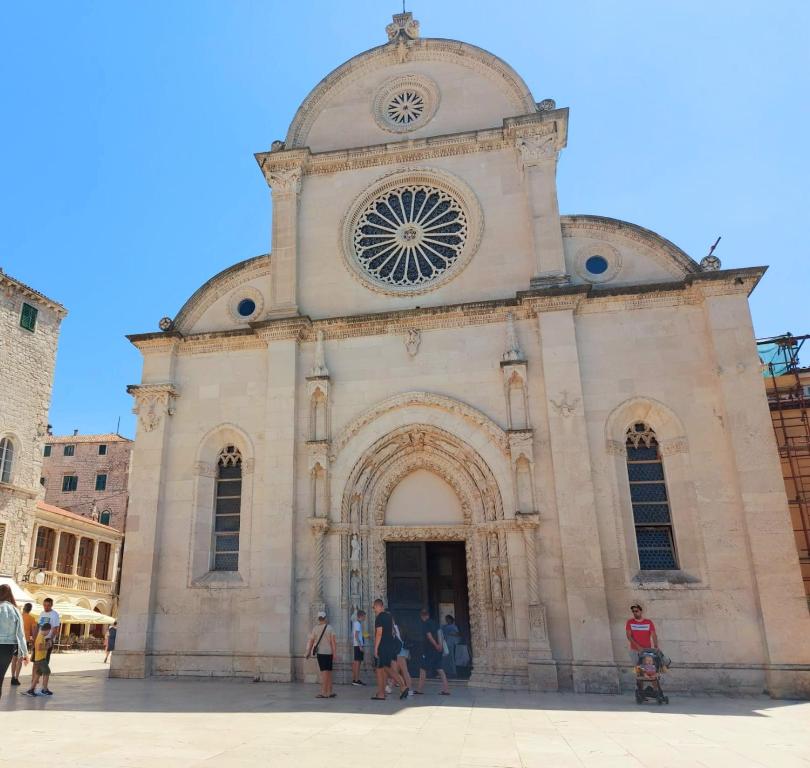 un grupo de personas de pie delante de una iglesia en Apartman Maslina, en Šibenik