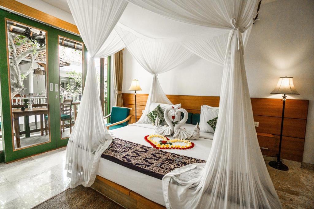 a bedroom with a bed with a mosquito net at Sabana Ubud in Ubud