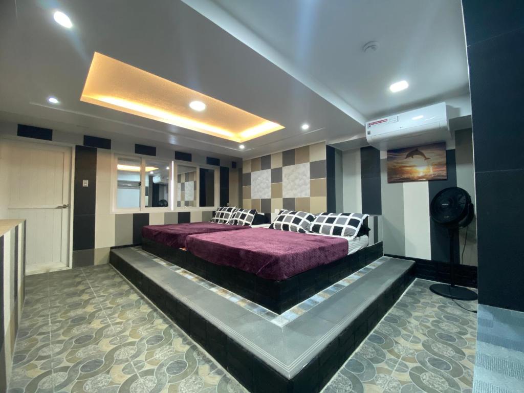Anak Jay Ang في بويرتو غاليرا: غرفة نوم بسرير ارجواني في غرفة