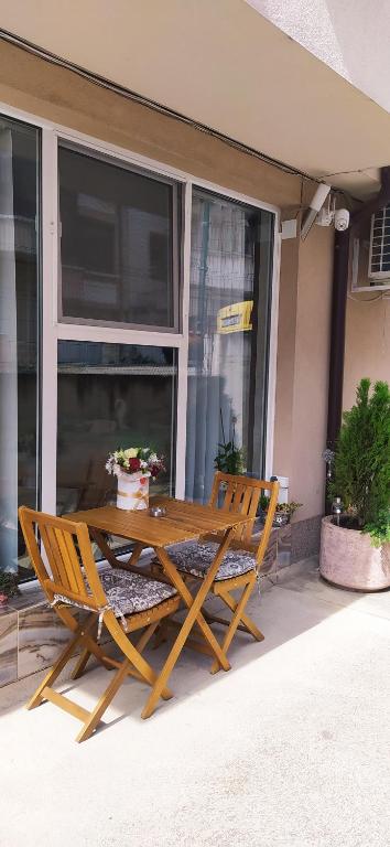 a wooden table and two chairs on a patio at Velvita Central in Sliven