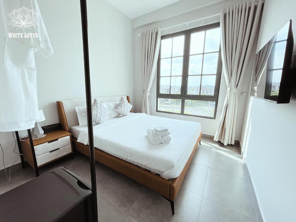 a bedroom with a bed and a large window at White Lotus Hotel - Swanbay in Phước Lý