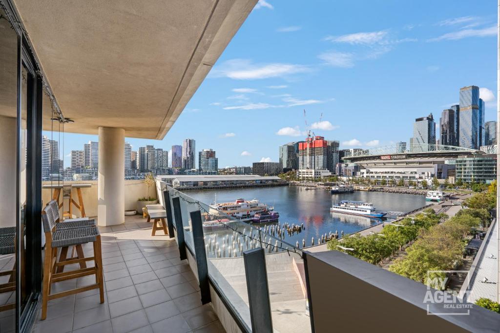 een balkon met uitzicht op een rivier en gebouwen bij Spectacular Victoria Harbour Apartment Docklands in Melbourne