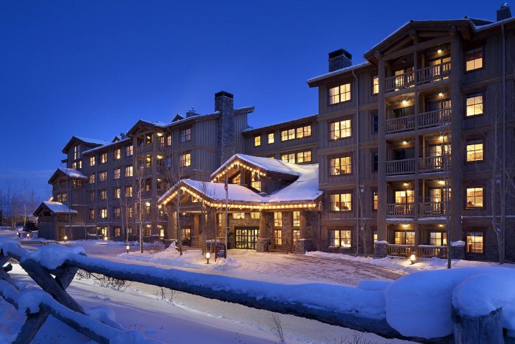 a large building in the snow at night at Teton Mountain Lodge and Spa, a Noble House Resort in Teton Village