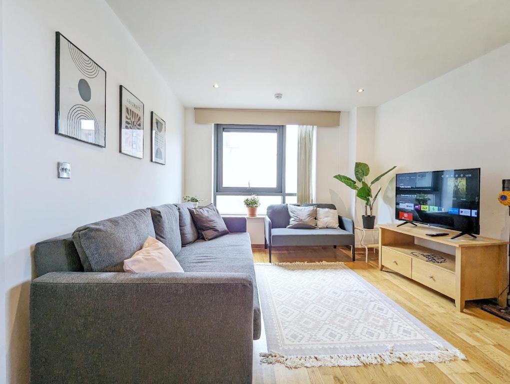 a living room with a couch and a flat screen tv at 2-bedroom Apt Near Key Attractions Free Parking in Liverpool