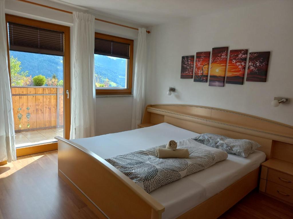 Un dormitorio con una cama con un osito de peluche. en Unterweg Hof, en Sarentino