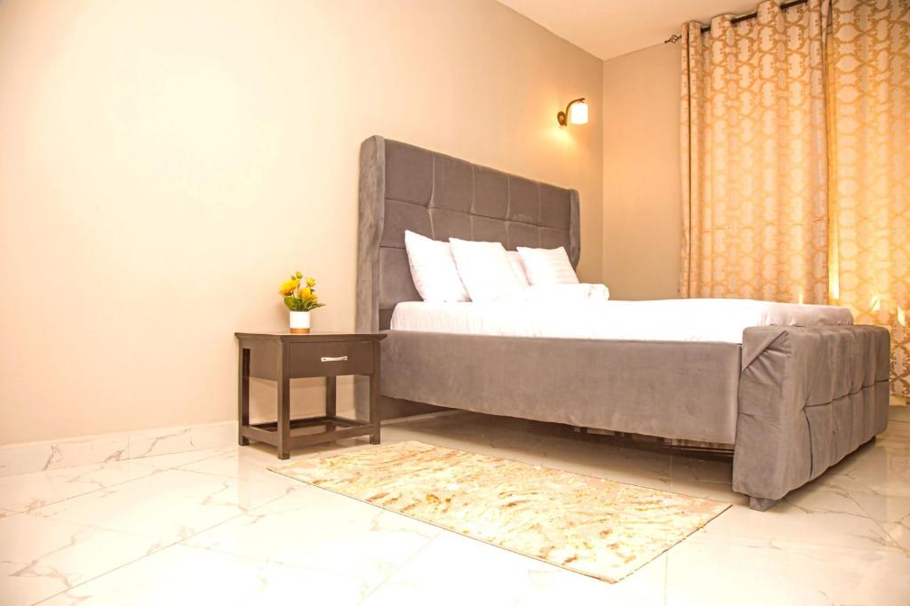 ein Schlafzimmer mit einem großen Bett und einem Tisch in der Unterkunft Nest and Nomad Homestay in Daressalam