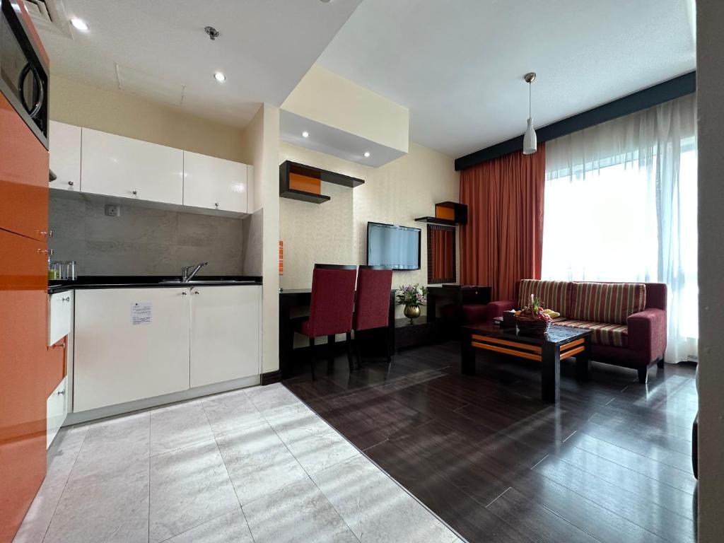 a kitchen and living room with a couch and a table at Marina View Deluxe Hotel Apartment in Dubai