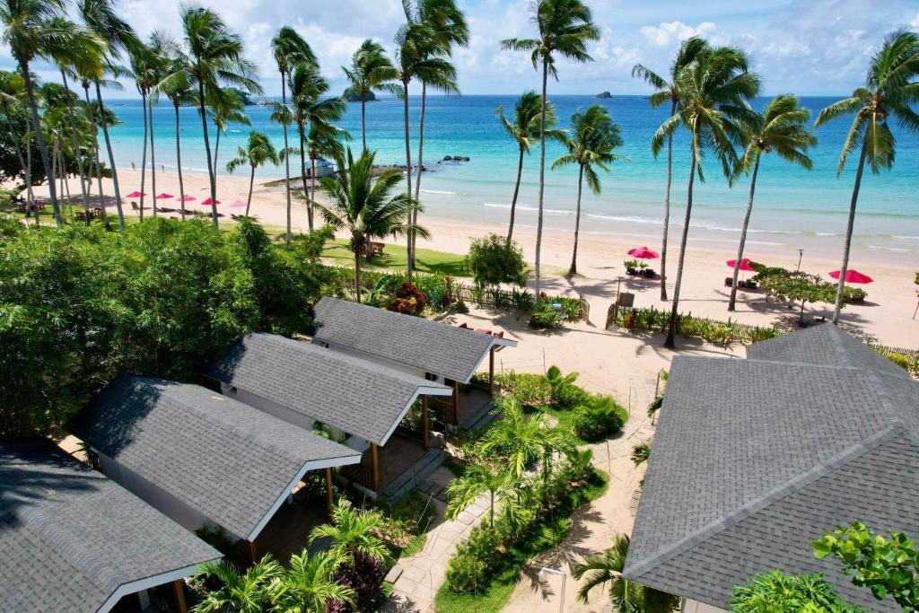 an aerial view of a resort with palm trees and the beach at Nacpan Beach Villas in El Nido