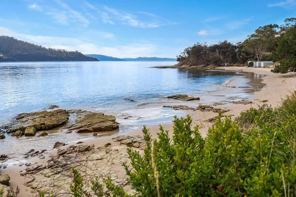 Blick auf einen Strand mit Felsen im Wasser in der Unterkunft Peaceful Bruny Island Shack in Dennes Point