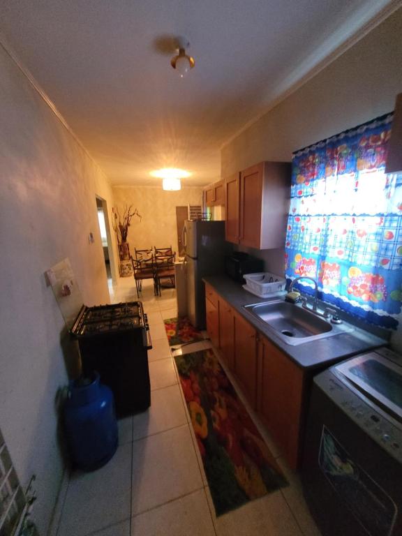 a small kitchen with a sink and a refrigerator at #1 Jacaranda Vacation Home in Spanish Town