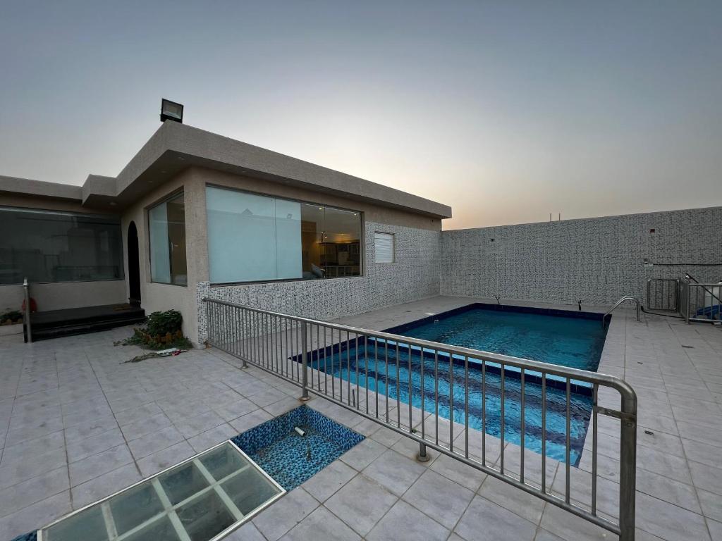 uma piscina em frente a uma casa em شاليه وردة الدرة em Unayzah