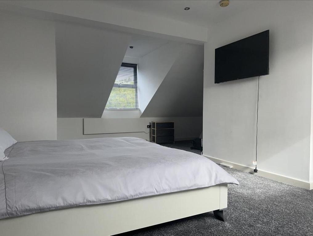 a white bedroom with a bed and a window at Homestay with free wi-fi, parking and more in Darlington