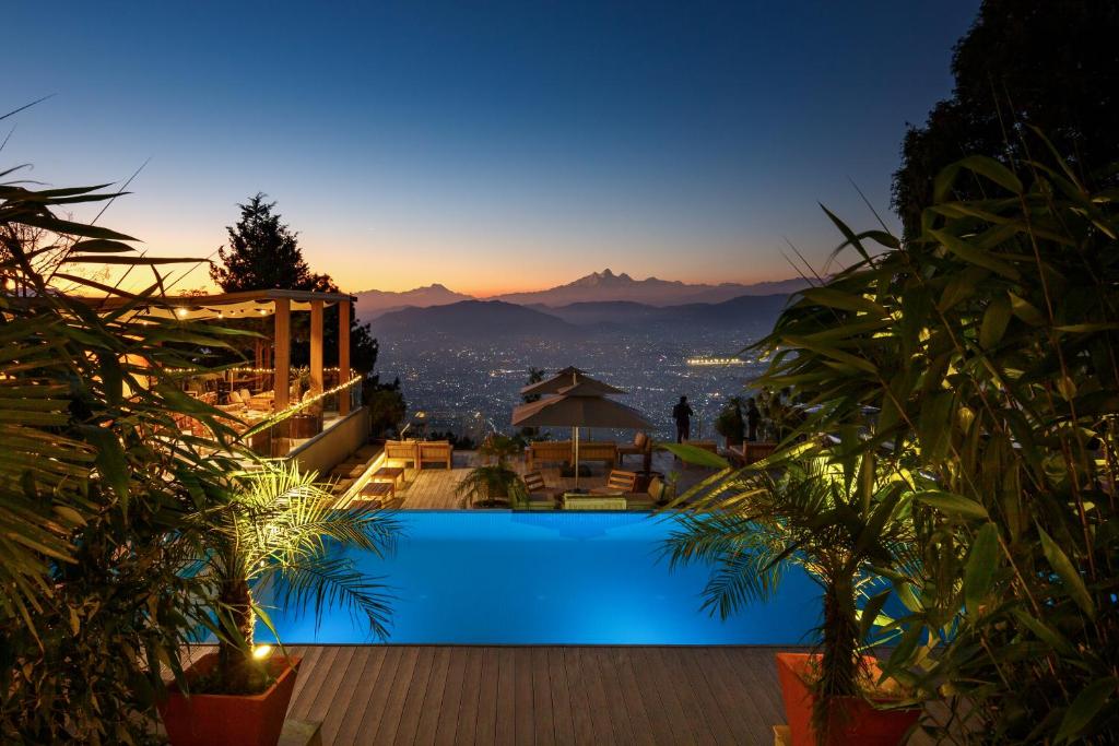 a pool with a view of the city at night at The Terraces Resort and Spa in Bhaktapur