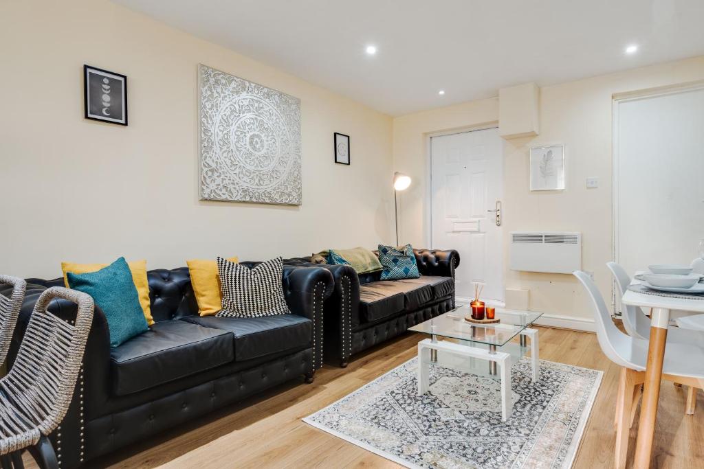 a living room with a black couch and a table at Huge 5BDRM Ensuite in Liverpool Monthly discounts Bu Hinkley Homes Short Lets & Serviced Accomodation in Liverpool