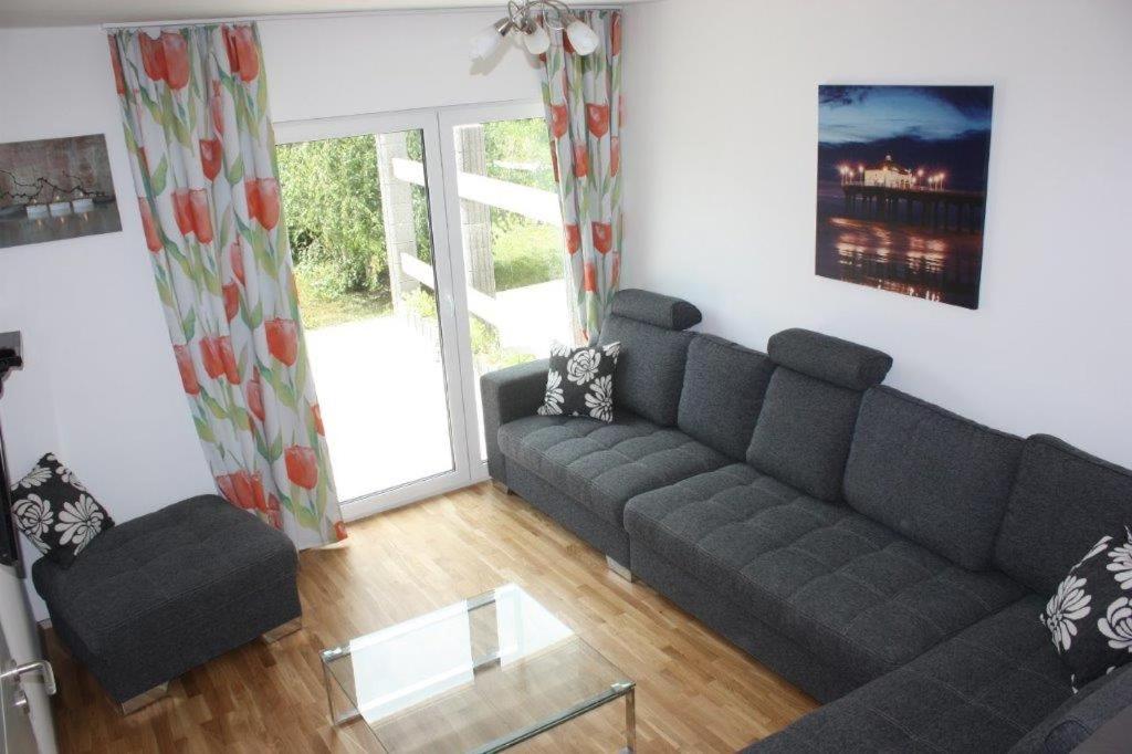 a living room with a couch and a glass table at zum Dünengras in Saal
