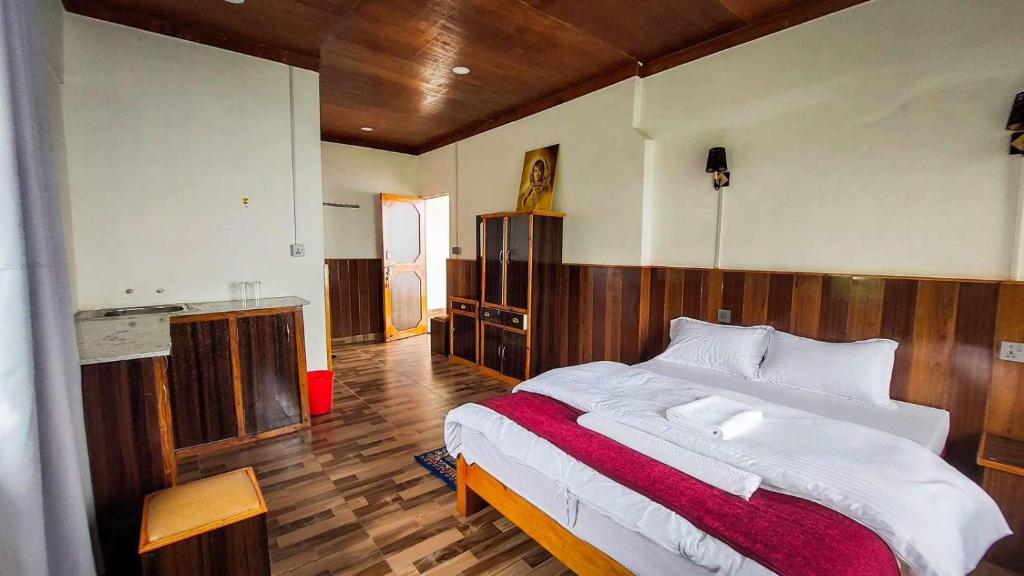 Schlafzimmer mit einem großen Bett mit einem Kopfteil aus Holz in der Unterkunft Panoramic View Guest House Sarangkot in Pokhara