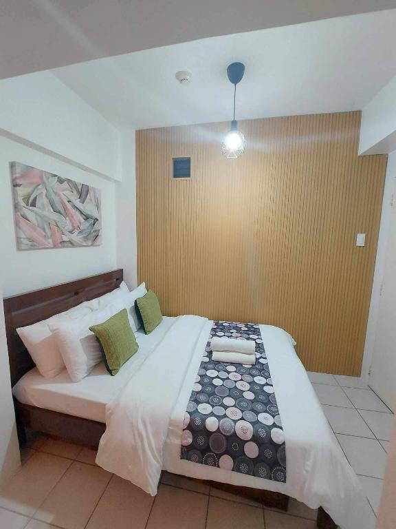 una camera da letto con un letto grande in una stanza di 2BR Condo in Tagaytay I Lake View I Fast Wifi I Free Parking a Tagaytay