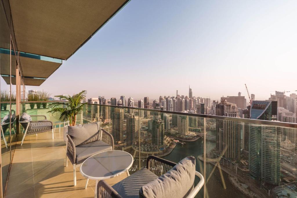 a balcony with chairs and a view of the city at Maison Privee - Modern Luxury Apt with Spectacular Dubai Marina Vws in Dubai