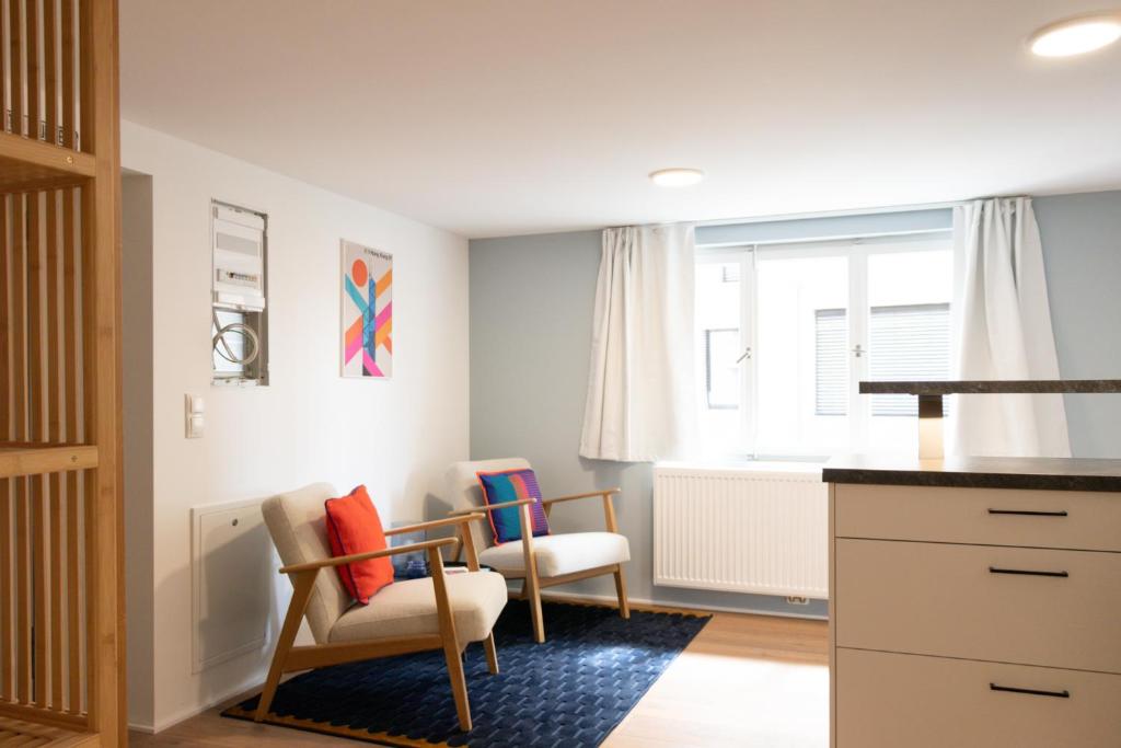 a living room with two chairs and a table at City Apartment Dornbirn, Hongkong 1 in Dornbirn