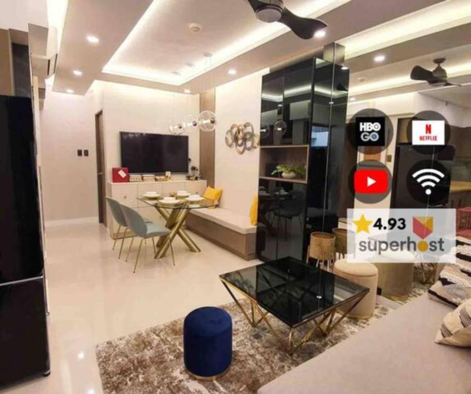 a living room with a table and a dining room at Stylish 2 Bedroom Condo Near BGC and Airport with Fast WiFi in Manila