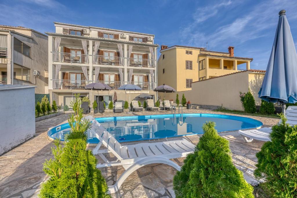 an apartment with a swimming pool and a building at Apartment-Haus Wolbeck in Poreč