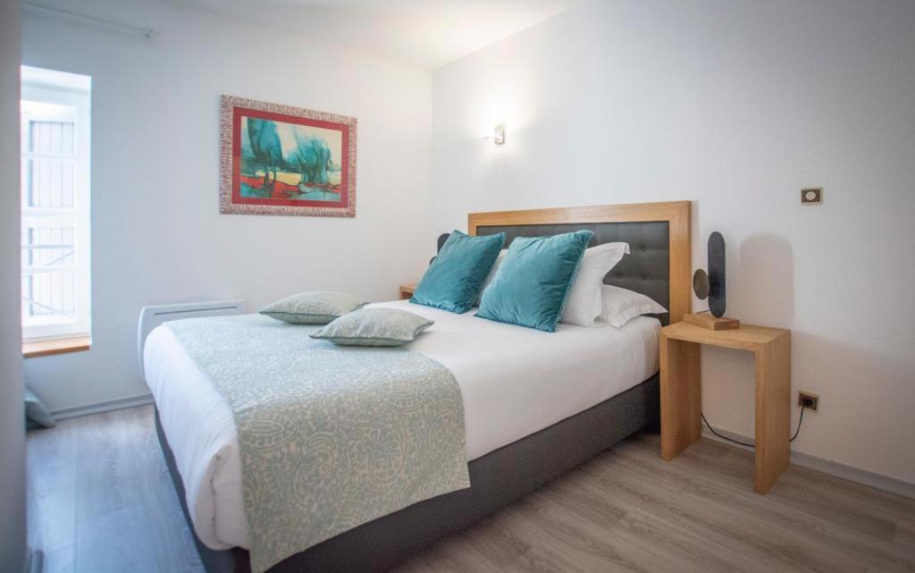 um quarto com uma cama grande e almofadas azuis em Auberge de l'Abbaye Cruis em Cruis