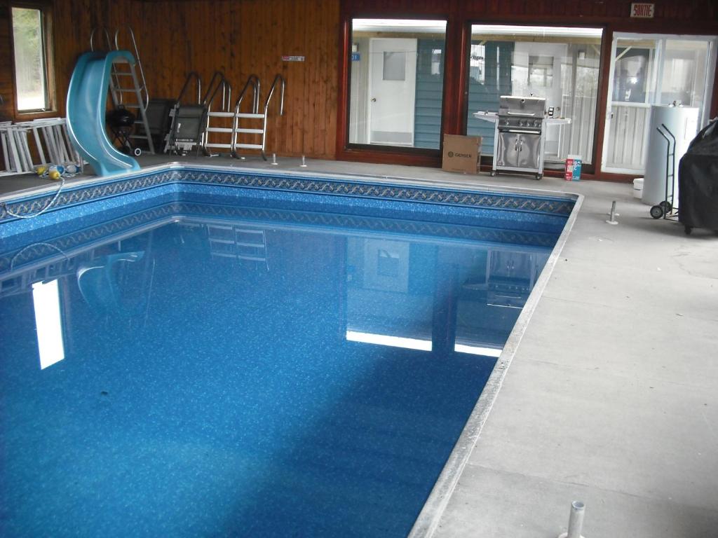 een groot blauw zwembad met een glijbaan bij Motel de l'anse in Port-Daniel