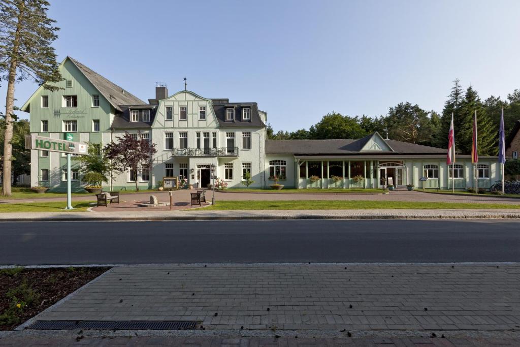 a large white house on the corner of a street at Seehotel Ecktannen in Waren