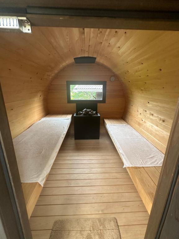 uma sauna com duas camas e uma televisão em 淡路島でサイコーのととのうを体験出来るサウナ宿たんざ二種類のフィンランドサウナを体験できます em Awaji