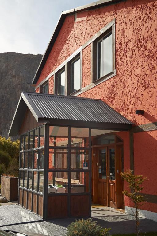 a red brick building with a black roof at Hotel Lunajuim in El Chalten