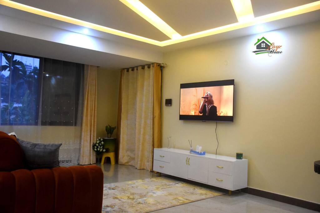 a living room with a tv on the wall at Bright cozy APT in the heart of Naguru in Kampala