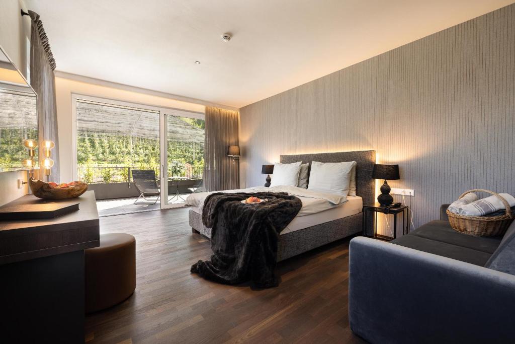 Hotel Finkenhof - Feel at home في تشينا: غرفة نوم مع سرير وغرفة معيشة