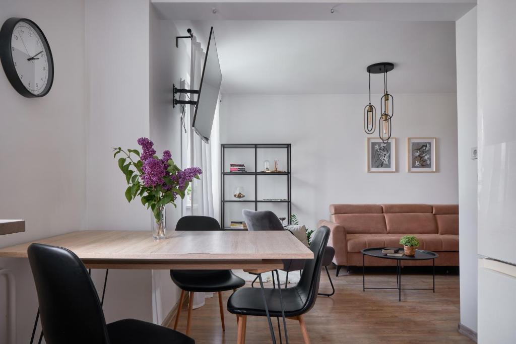 une salle à manger avec une table, des chaises et un canapé dans l'établissement Resort Stories Išskirtiniai 7 vietų apartamentai Birštone, à Birštonas