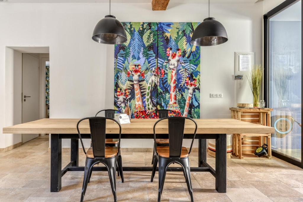 uma sala de jantar com uma grande mesa de madeira e cadeiras em La Remise des Amis - Maison rénovée au calme em Peyriac-de-Mer
