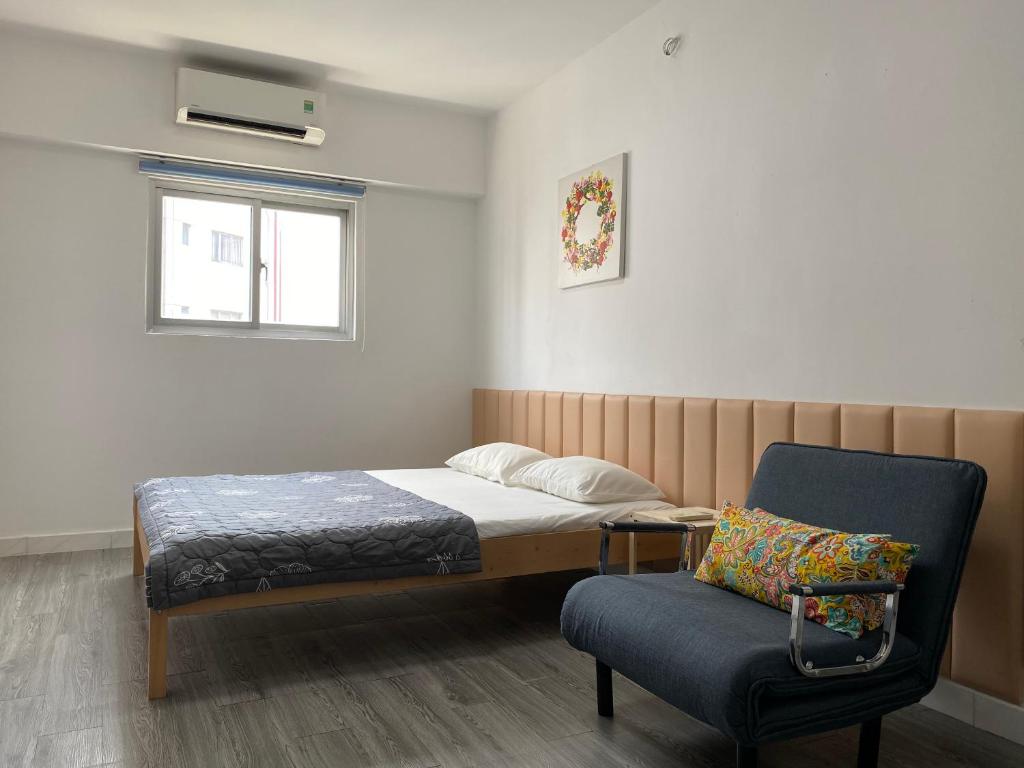 ein Schlafzimmer mit einem Bett, einem Stuhl und einem Fenster in der Unterkunft Modern 1 bedroom apartment - C' House in Ho-Chi-Minh-Stadt