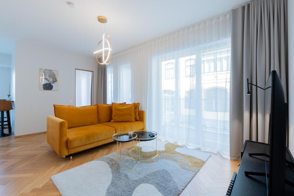 uma sala de estar com um sofá amarelo e uma mesa em Cozy Stay Apartment em Pärnu