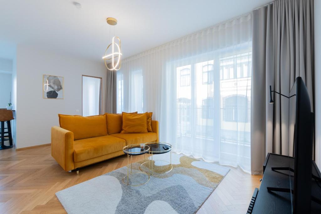 a living room with a yellow couch and a table at Cozy Stay Apartment in Pärnu