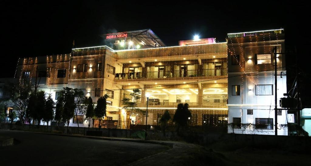 een gebouw 's nachts waar mensen voor lopen bij Hotel Indira Nikunj in Rishīkesh