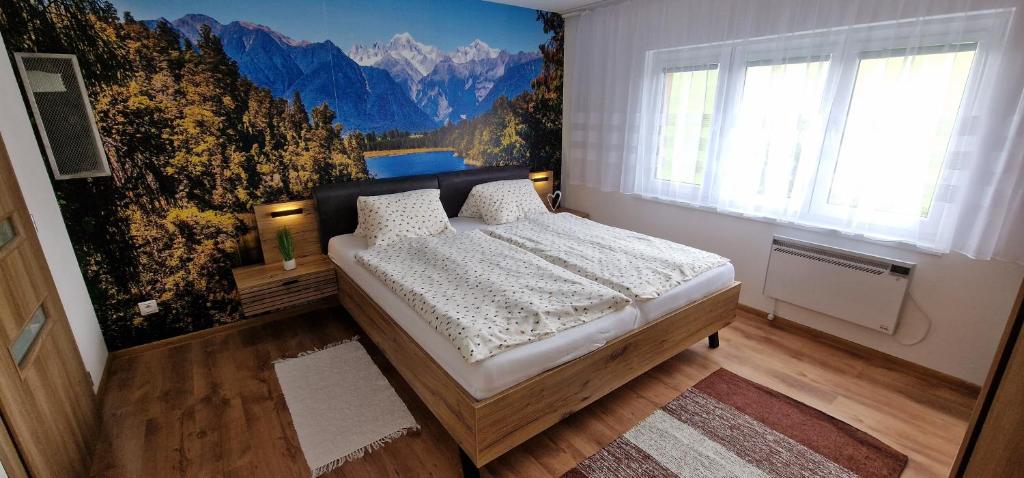 a bedroom with a bed with a mural of mountains at Chata Family s vírivkou v Slovenskom raji in Spišská Nová Ves
