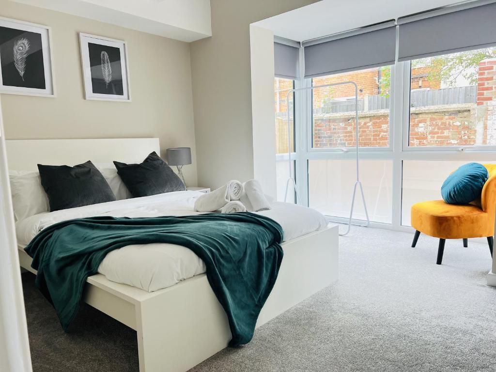 1 dormitorio blanco con 1 cama y 1 silla en Brand New 1 Bed with Sofabed, Private Patio & Electric Parking Bay, 5min Walk to Racing & Main Strip LONG STAY WORK CONTRACTOR LEISURE - AMBER en Newmarket