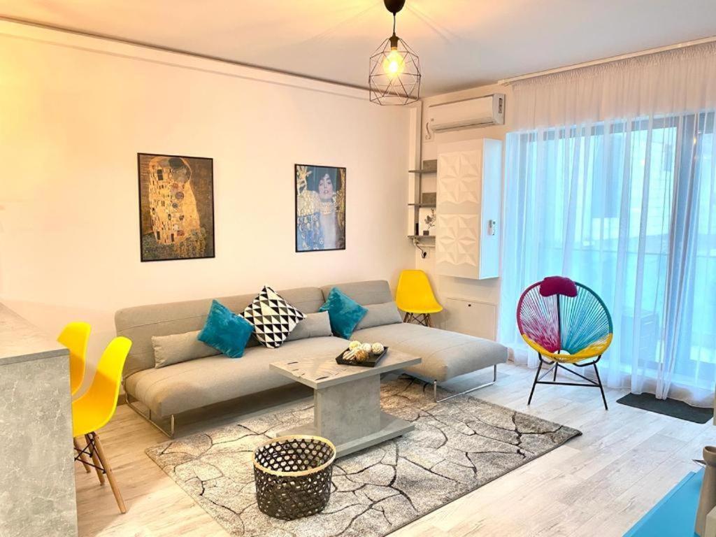 un salon avec un canapé, une table et des chaises dans l'établissement Apartament Happy Sea View, à Mamaia Nord – Năvodari