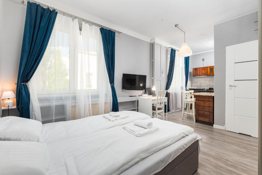 um quarto com uma grande cama branca com cortinas azuis em Elektoralna 19 by Homeprime em Varsóvia