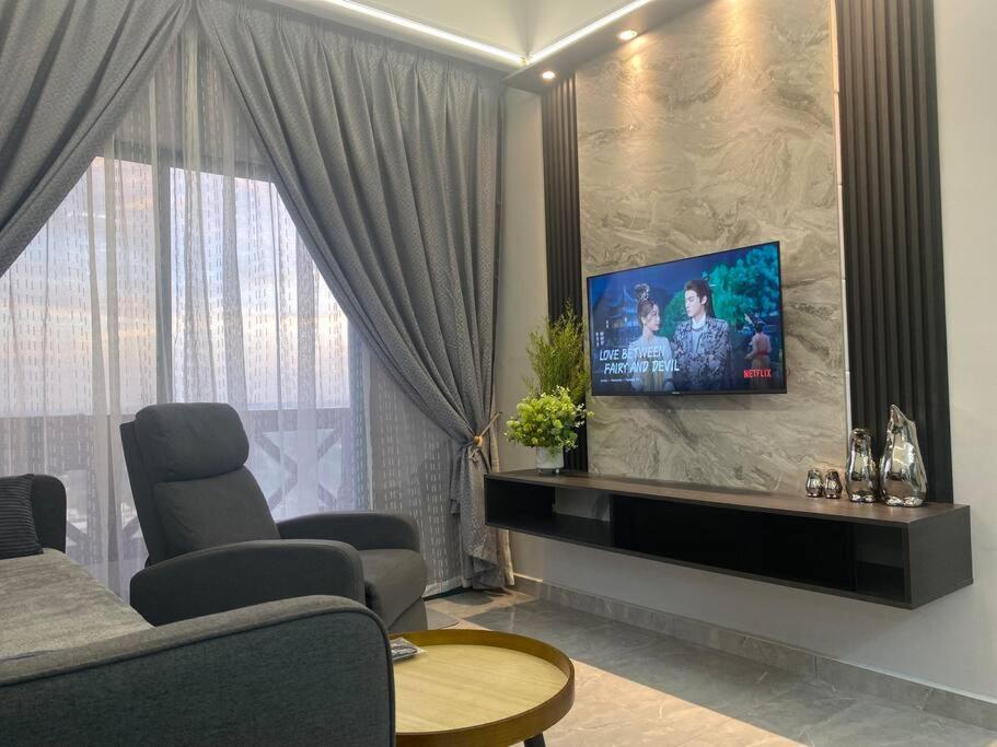 a living room with a flat screen tv on a wall at Home Sweet Home 2 rooms Apartment in Melaka
